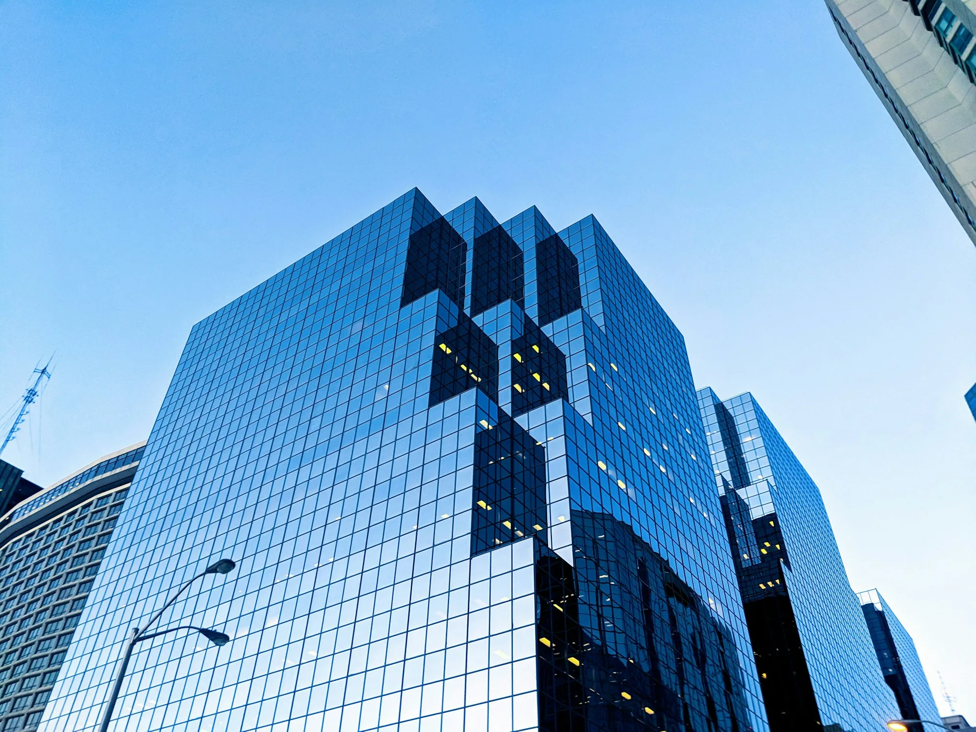 Reflective glass office tower against a blue sky