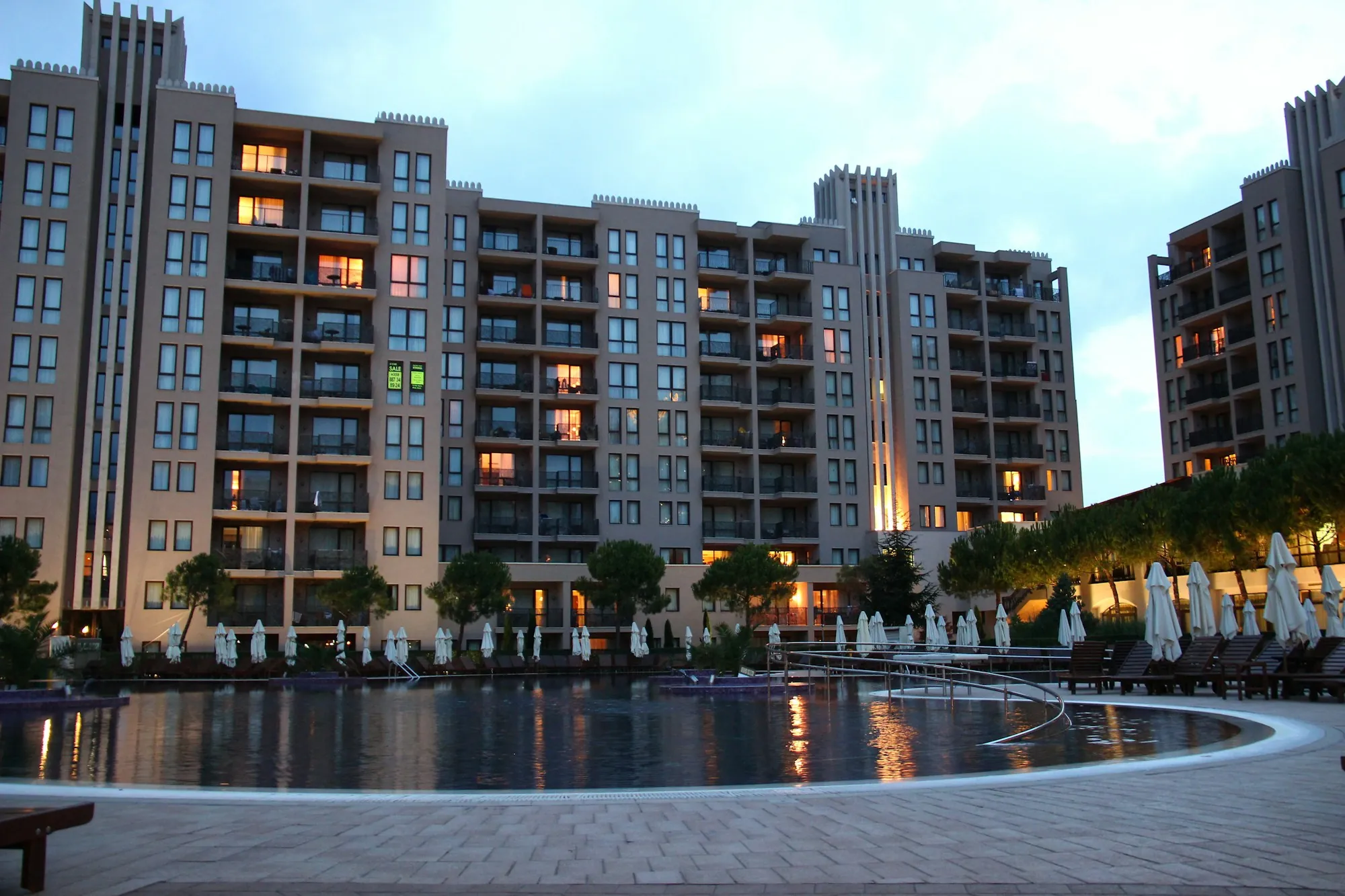 Apartment complex with a pool lit in the evening, illustrating first rental property cash flow for buyers in Mojave