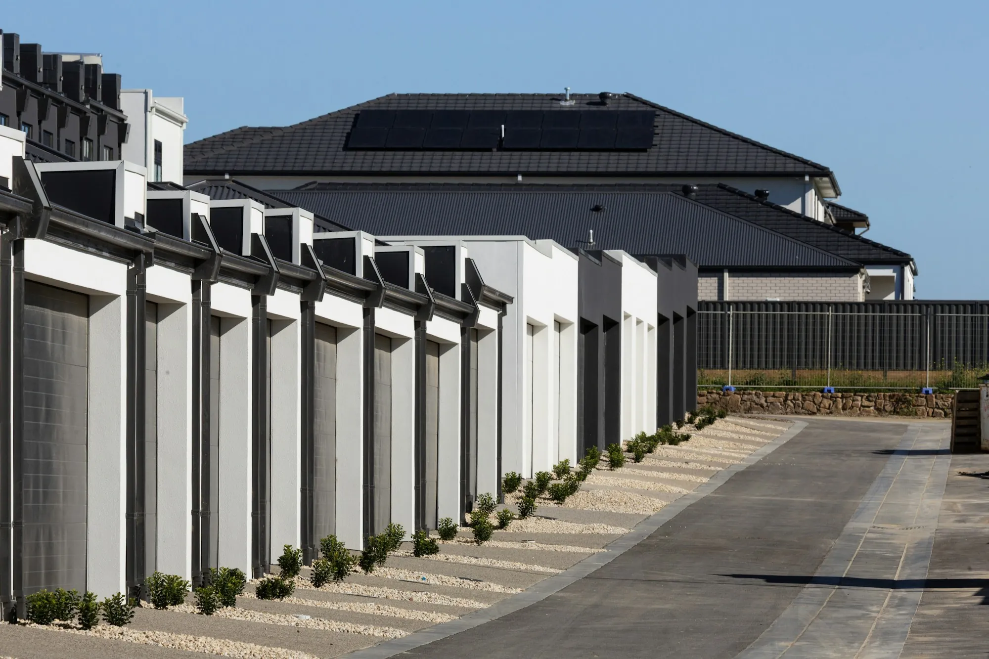 Row of white townhouse garages along a private drive
