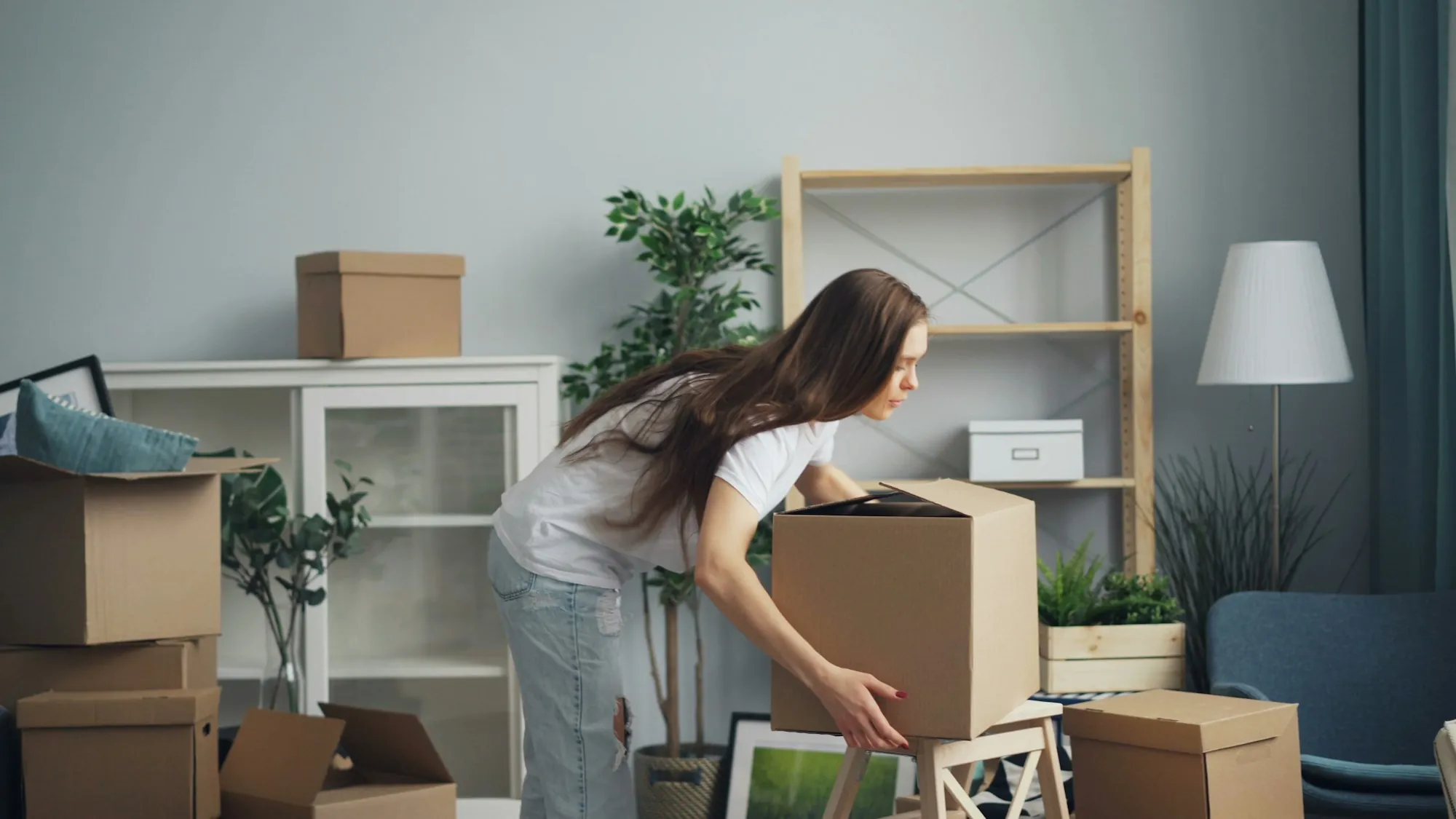Woman unpacking moving boxes in a bright room